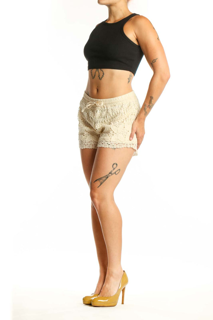 Cream lace shorts with crochet design and drawstring waist, front view on model