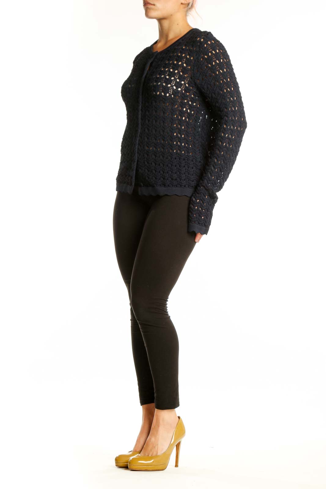 Black openwork knit cardigan with button-front closure and long sleeves, worn with black pants