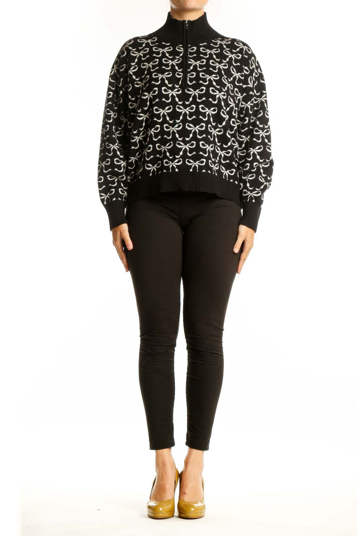 Black pullover knit with cream bow print pattern, half-zip neckline, and ribbed collar by Maeve