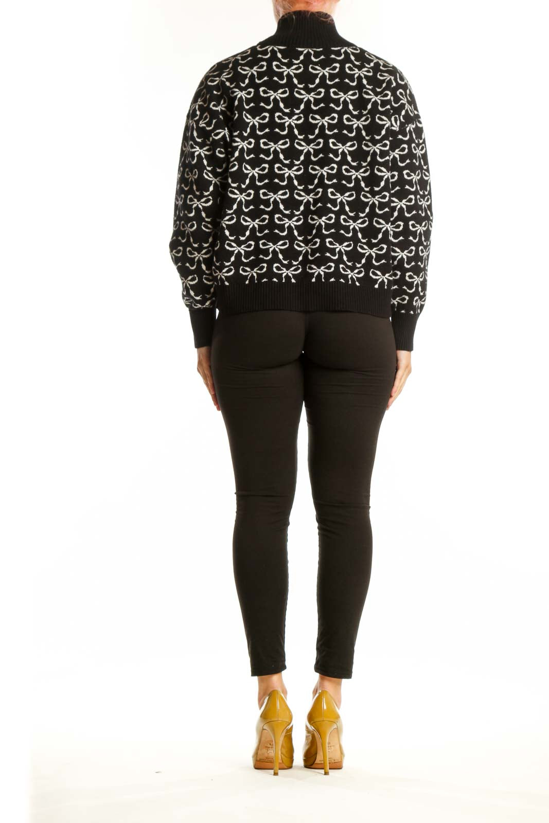 Back view of black bow print pullover knit showing cropped silhouette and voluminous sleeves