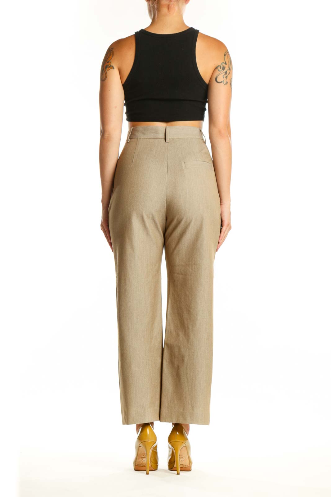Back view of beige paperbag waist trousers showing structured waistband and flattering silhouette