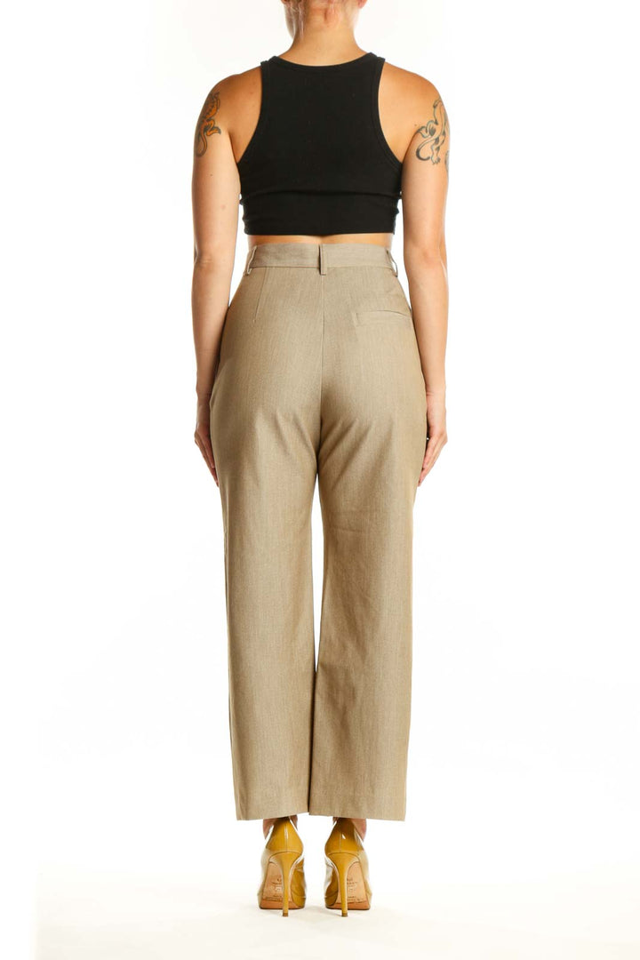 Back view of beige paperbag waist trousers showing structured waistband and flattering silhouette
