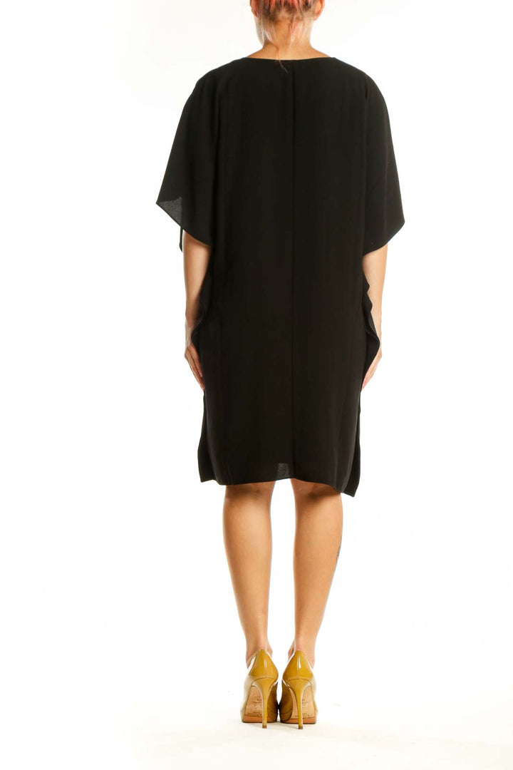 Black V-neck caftan dress with asymmetrical hemline, back view on model