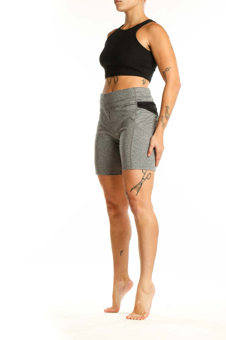 Front view of gray polyester Athleta bike shorts with high-waisted design and side pockets on model