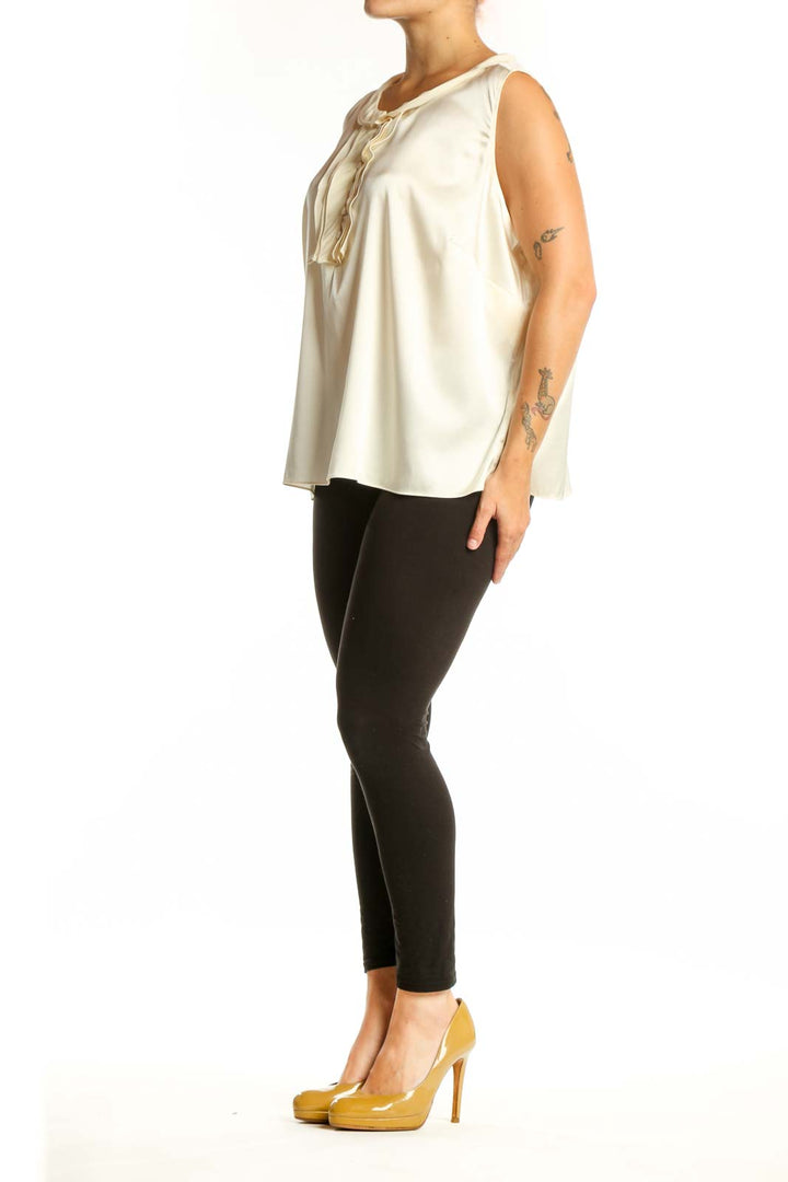 Cream silk sleeveless top with ruffle neckline detail, front view on model