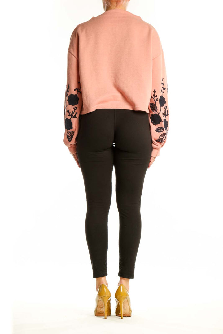 Peach cropped sweatshirt with black botanical embroidery, back view