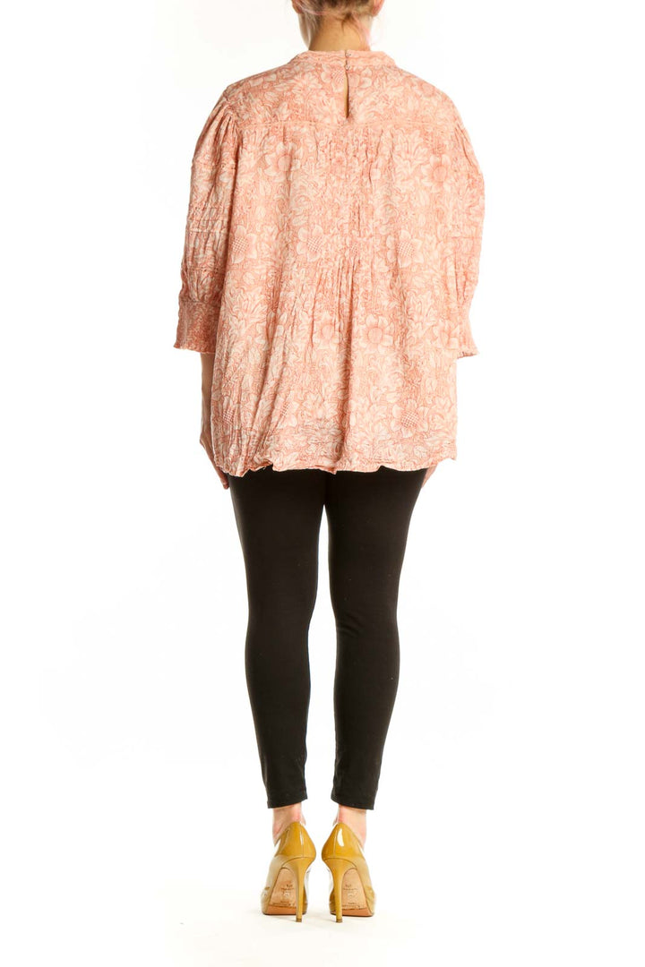 Peach floral cotton blouse with pleated back detail and asymmetrical hem, back view on model
