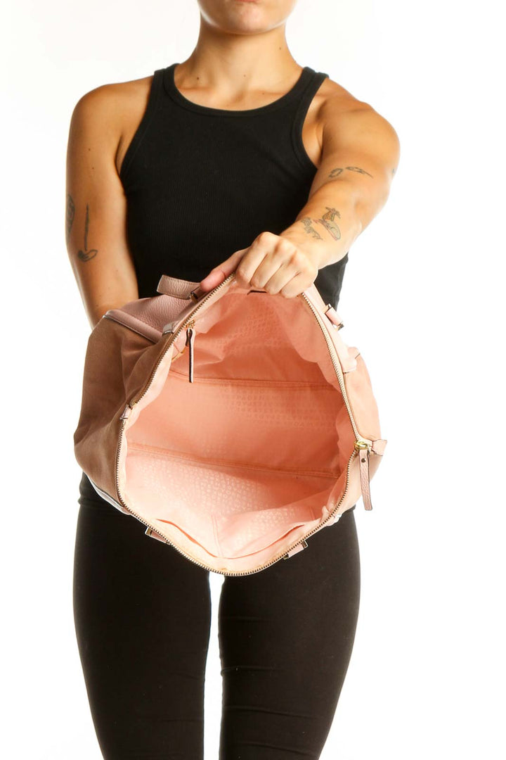 Blush pink leather Kate Spade tote bag worn on shoulder, back view