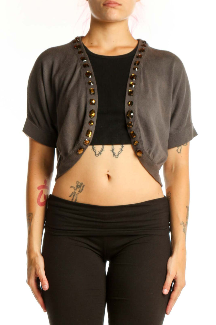 Gray studded cropped cardigan knit with metal stud trim, worn over black top