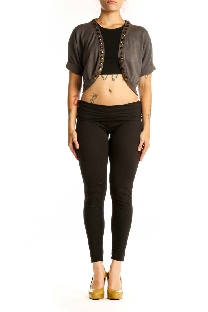 Gray studded cropped cardigan knit with metal stud trim, worn over black top