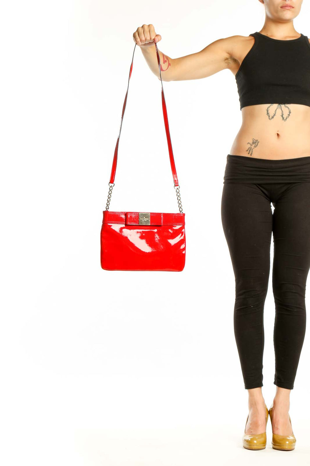 Kate Spade Red Patent Leather Crossbody Bag with bow detail and chain straps held in hand