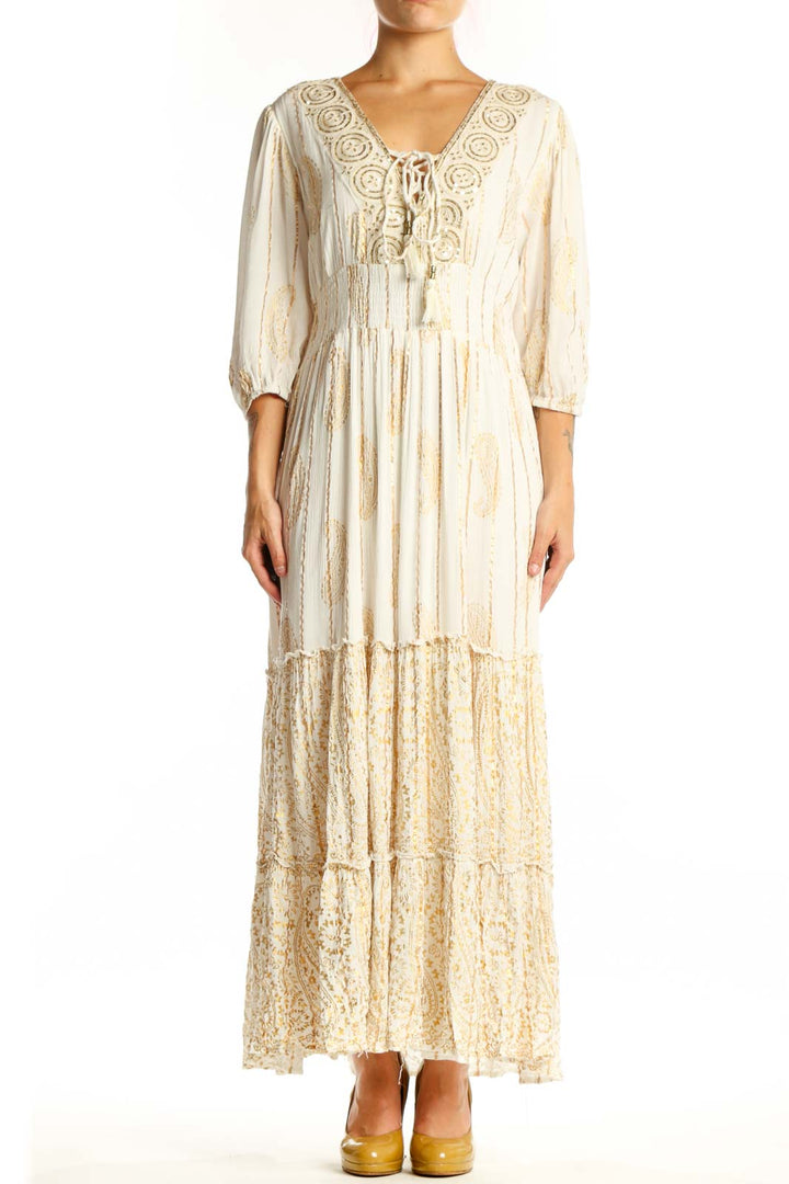 Front view of cream viscose maxi dress with embroidered V-neckline, three-quarter sleeves, and tiered lace hem