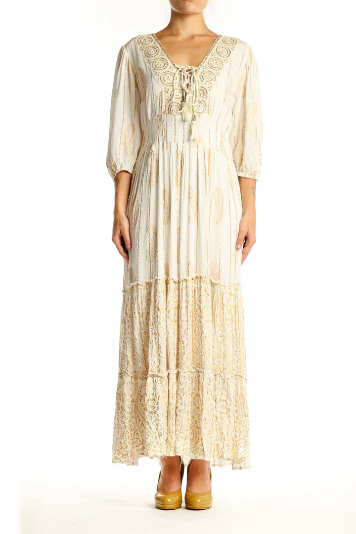 Front view of cream viscose maxi dress with embroidered V-neckline, three-quarter sleeves, and tiered lace hem
