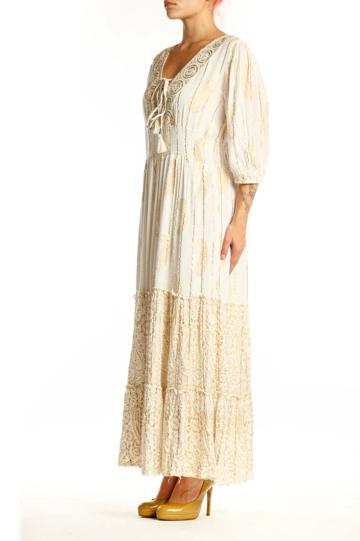 Front view of cream viscose maxi dress with embroidered V-neckline, three-quarter sleeves, and tiered lace hem