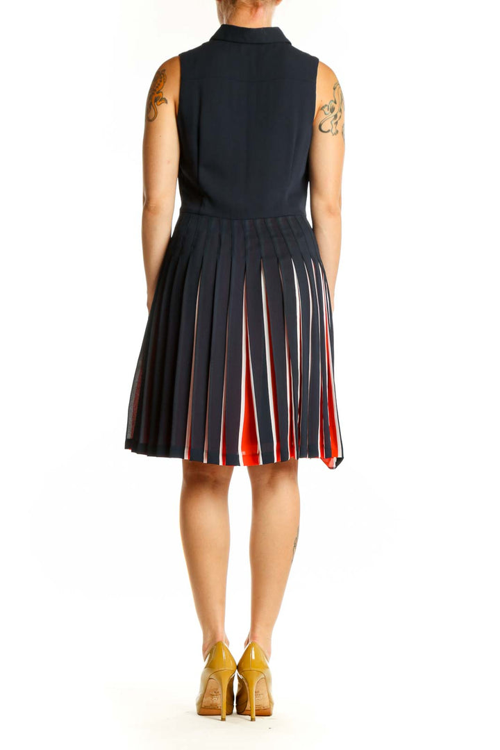 Back view of navy pleated dress showing red and white striped pleated skirt design