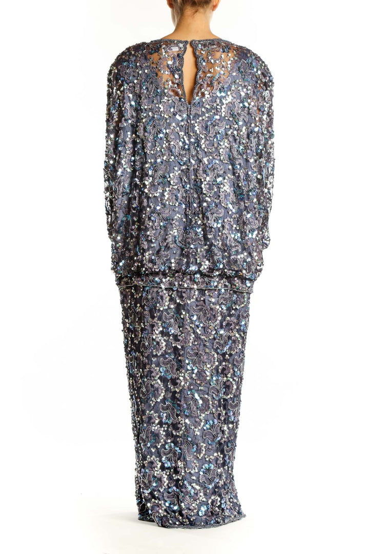 Back view of silver sequin evening gown showing elegant drape and slit detail