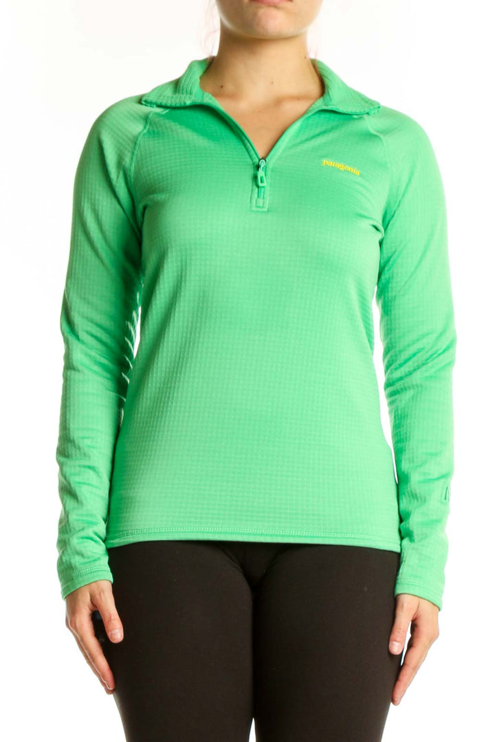 Green Patagonia quarter-zip long sleeve athletic top with yellow logo, front view on model