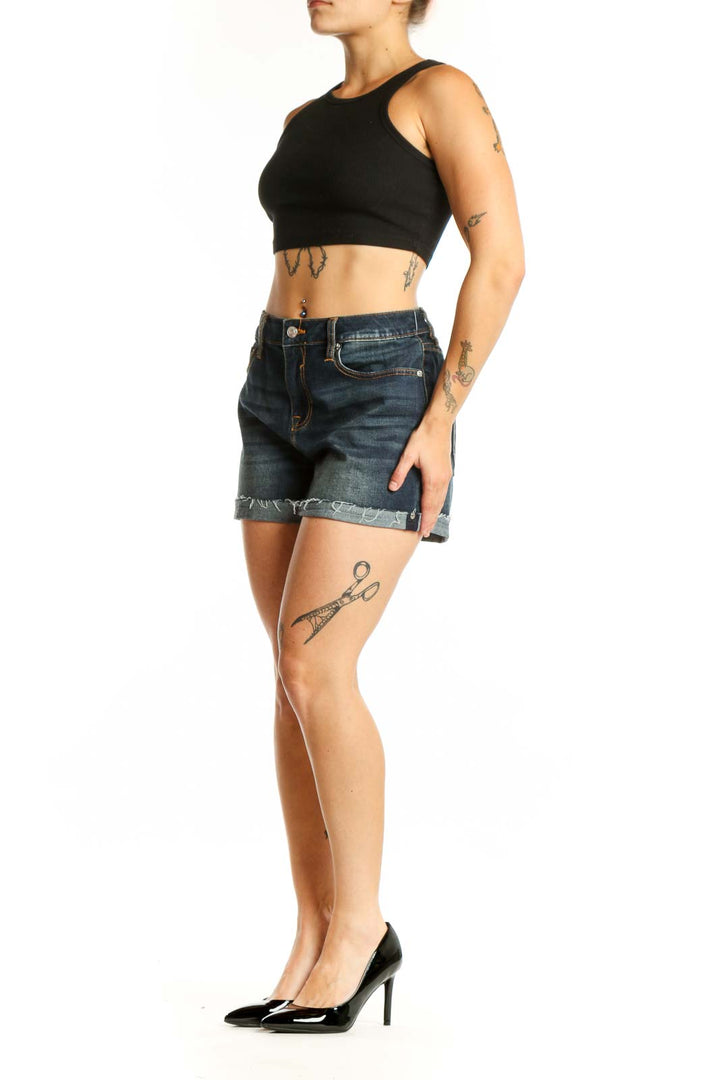 Dark blue denim cut-off shorts with distressed hem and orange stitching, front view