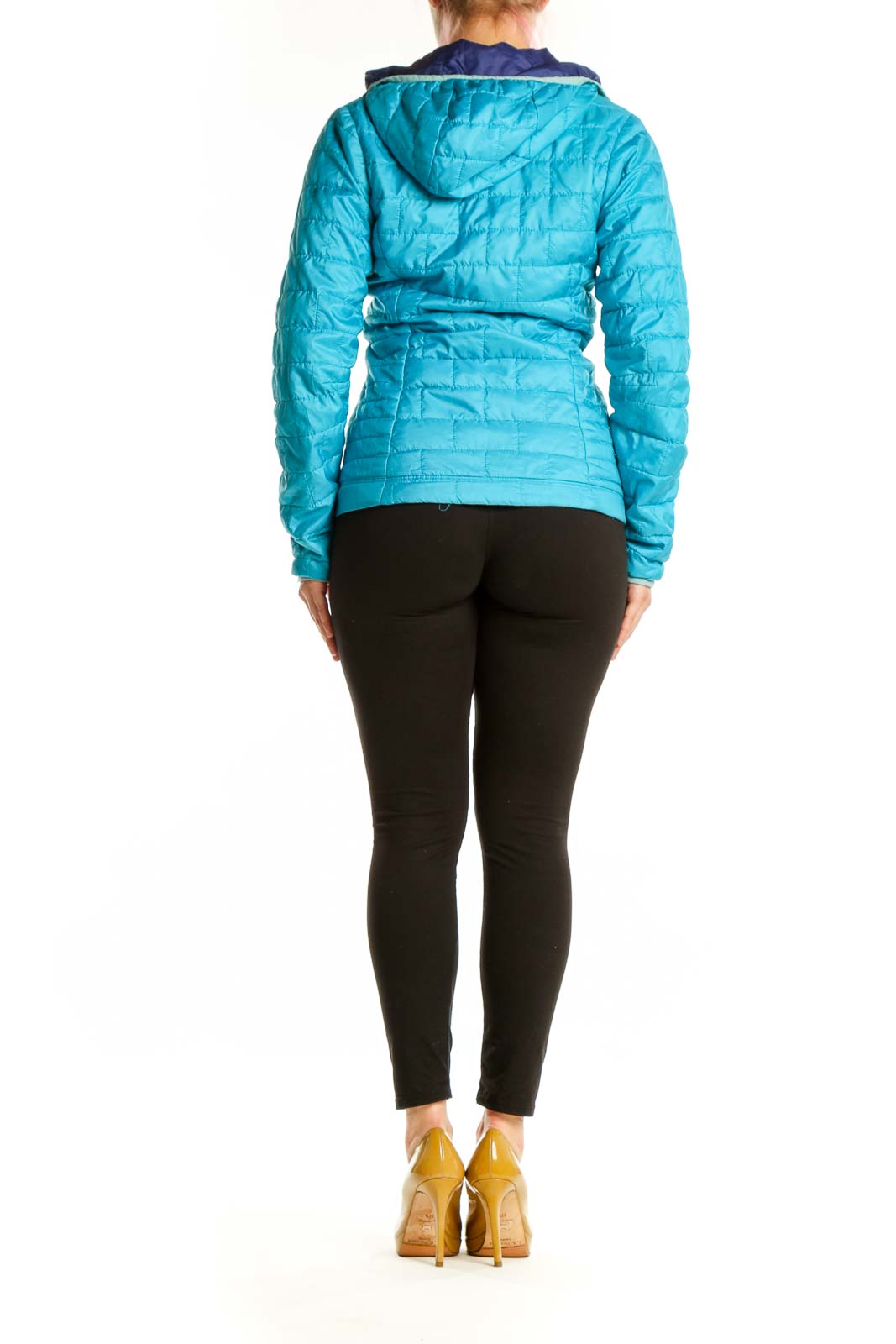 Back view of turquoise quilted Patagonia puffer jacket with navy hood lining on woman