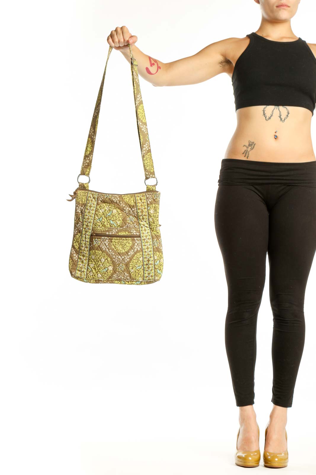 Yellow quilted Vera Bradley crossbody bag with geometric pattern and adjustable fabric straps held in hand