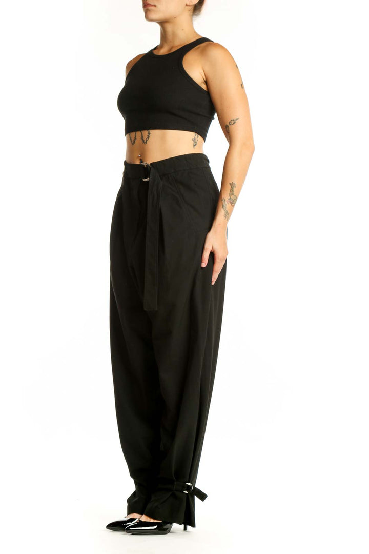 Black paperbag waist pants with tie belt and ankle bow detail, front view