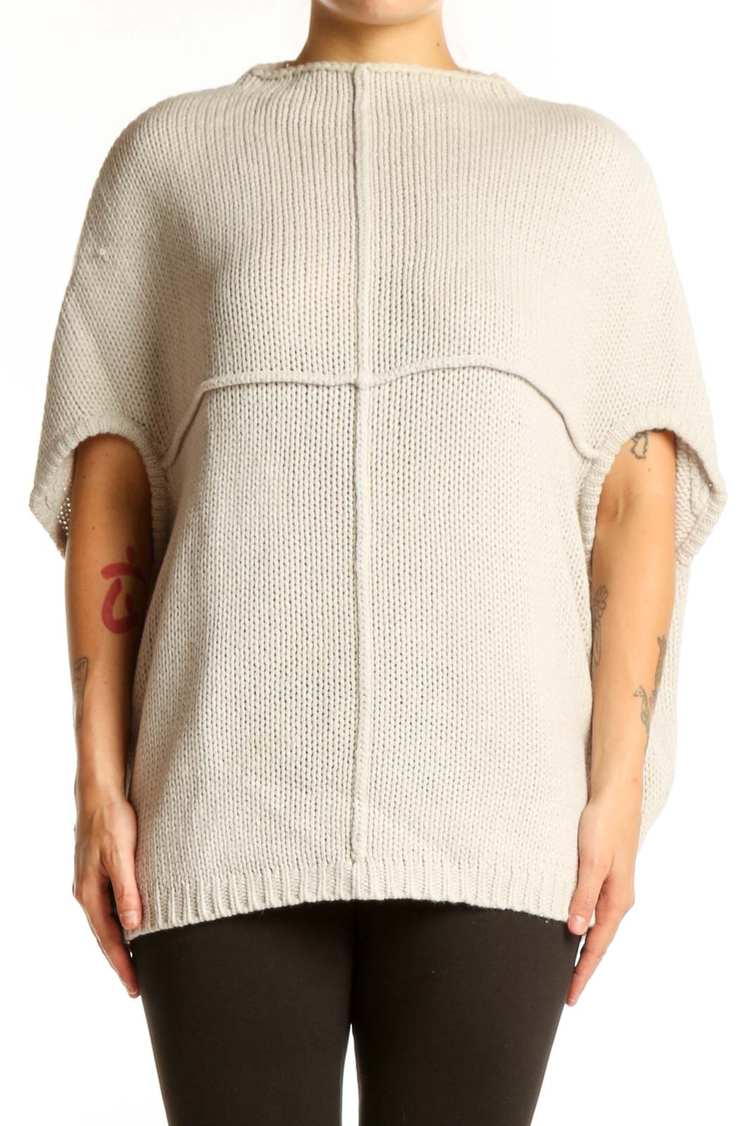 Cream acrylic knit poncho with cutout sleeves, back view showing ribbed texture and oversized fit