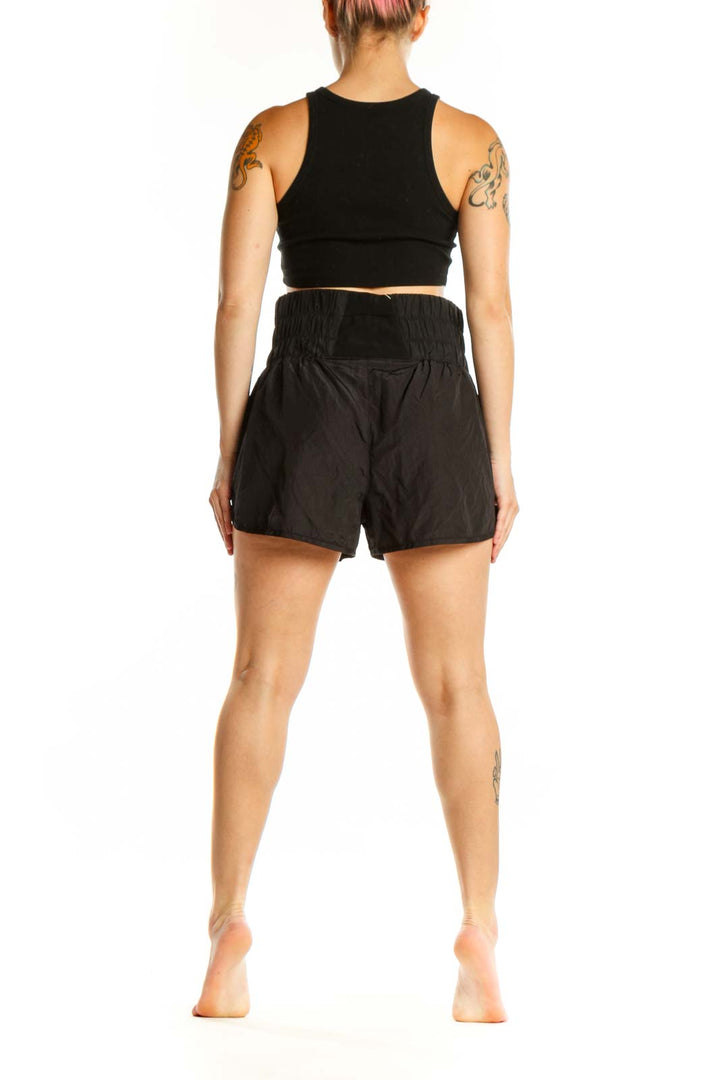 Black athletic shorts with gathered elastic waistband, side view on model