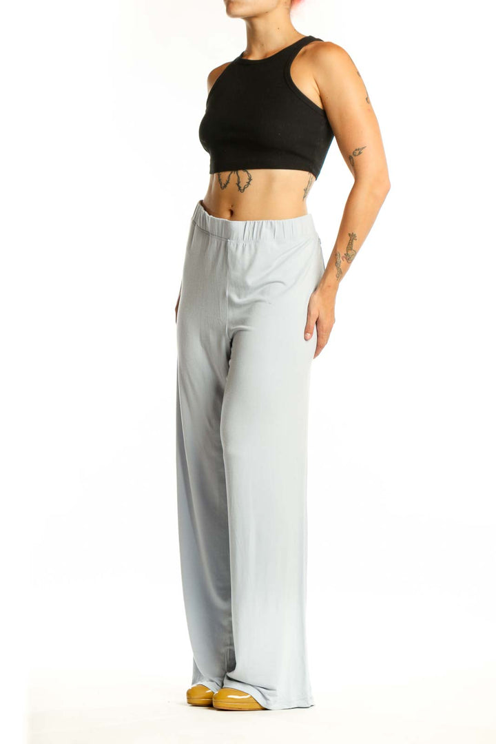 Gray wide leg pants with elastic waistband, front view on model wearing black crop top
