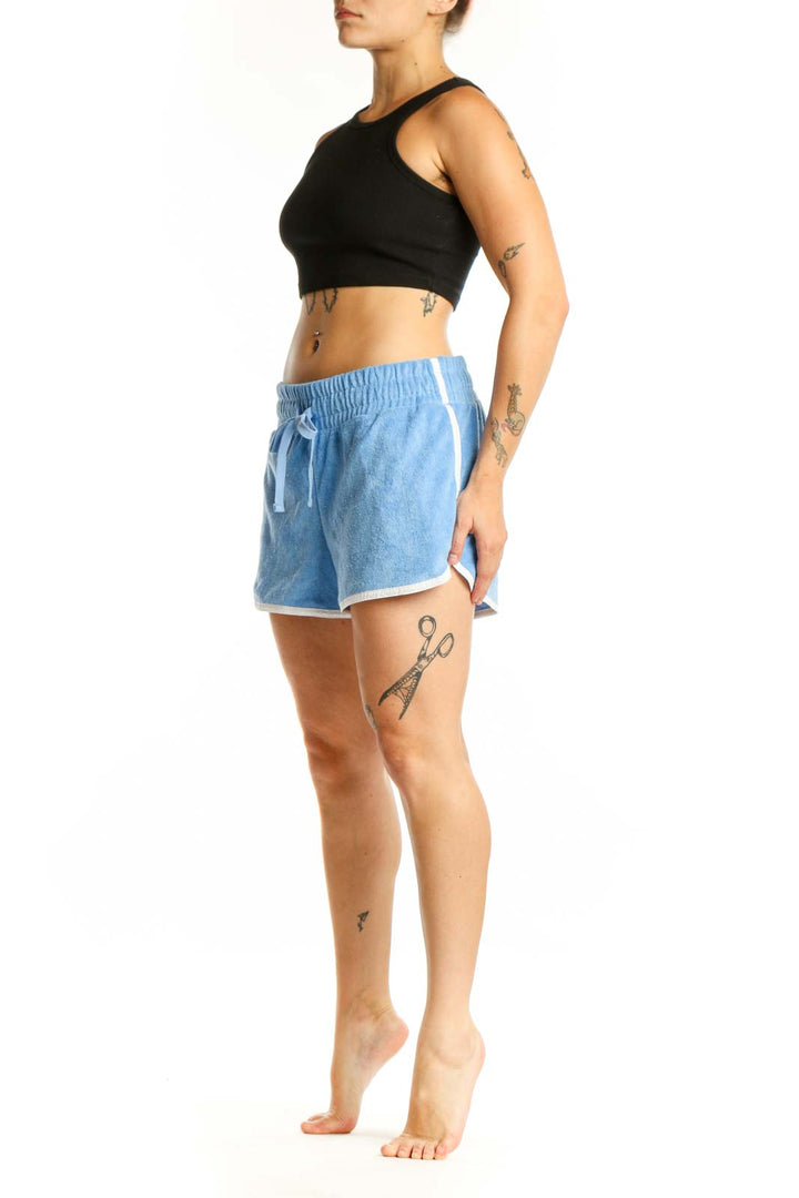 Light blue denim athletic shorts with drawstring waist and white contrast trim, front view