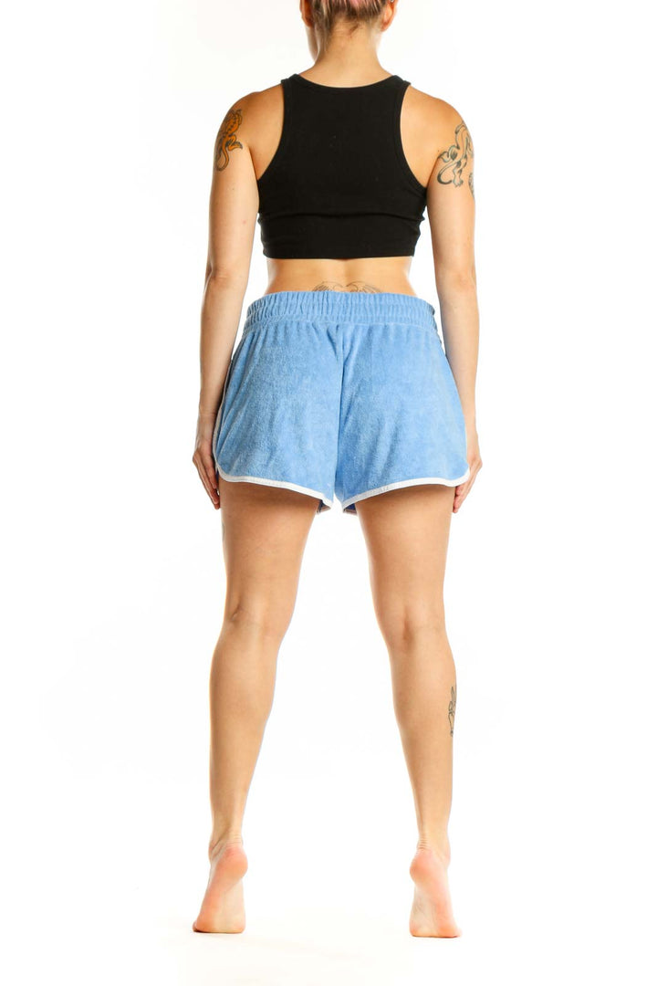 Light blue denim athletic shorts with drawstring waist and white contrast trim, back view