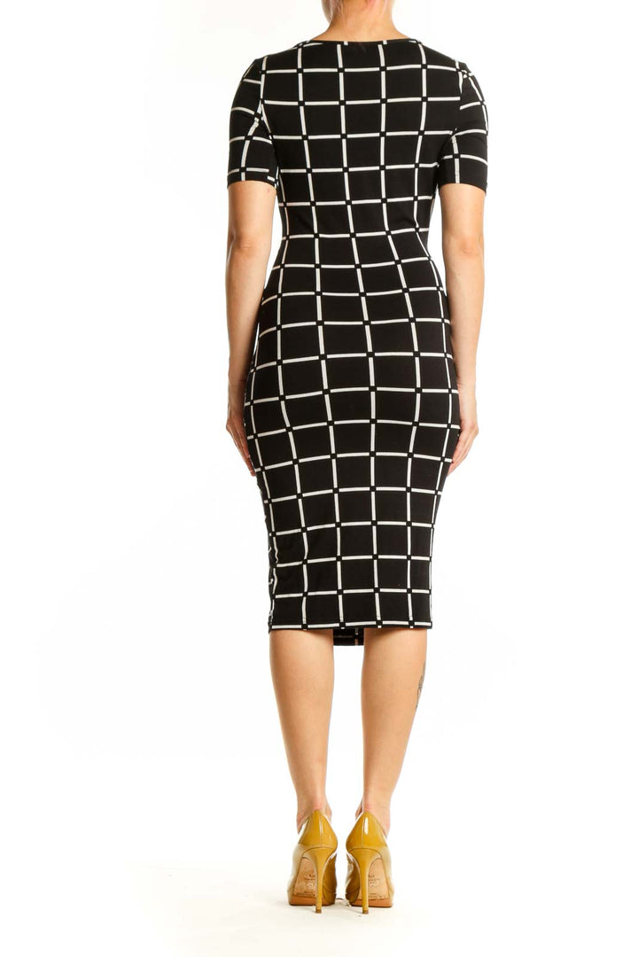 Black and white grid pattern midi dress with short sleeves and ruched waist detail, back view