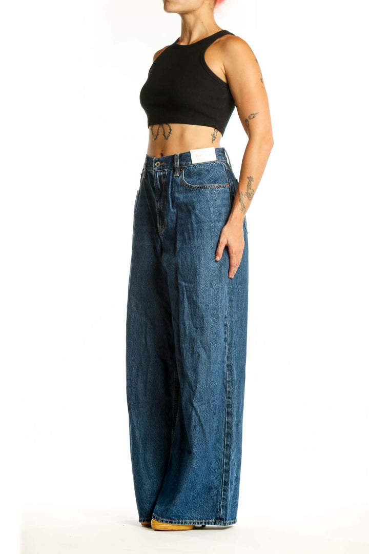 Front view of blue wide-leg denim jeans with five-pocket styling and button fly closure