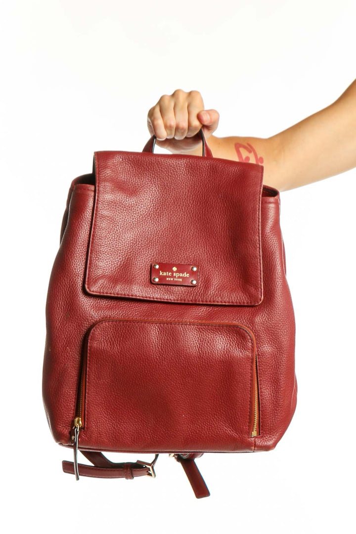 Burgundy leather Kate Spade backpack with top handle and front pocket, displayed from front view