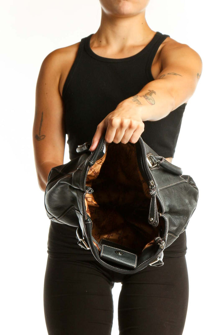 Black leather and canvas Tignanello shoulder tote bag worn on shoulder, side view
