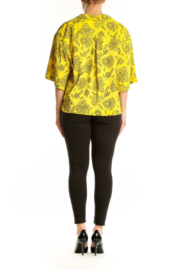 Yellow floral button-up blouse with botanical print, back view showing relaxed fit
