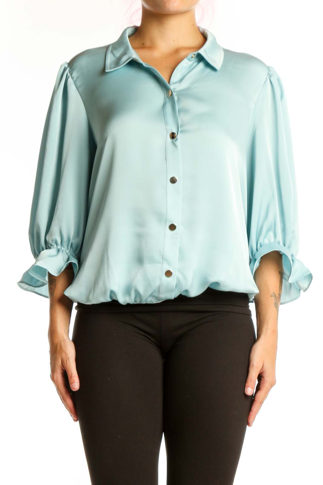 Front view of pale blue puff sleeve button-up blouse with rolled cuffs and brown buttons
