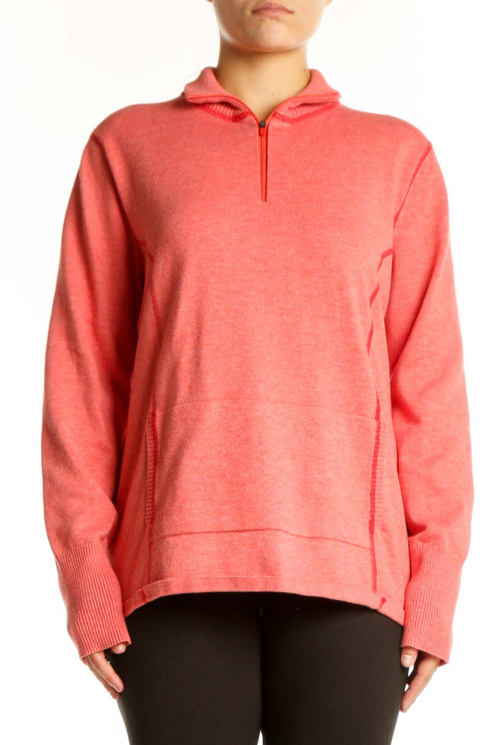Woman wearing coral Eddie Bauer zip hoodie with quarter-zip design and hood, paired with black leggings