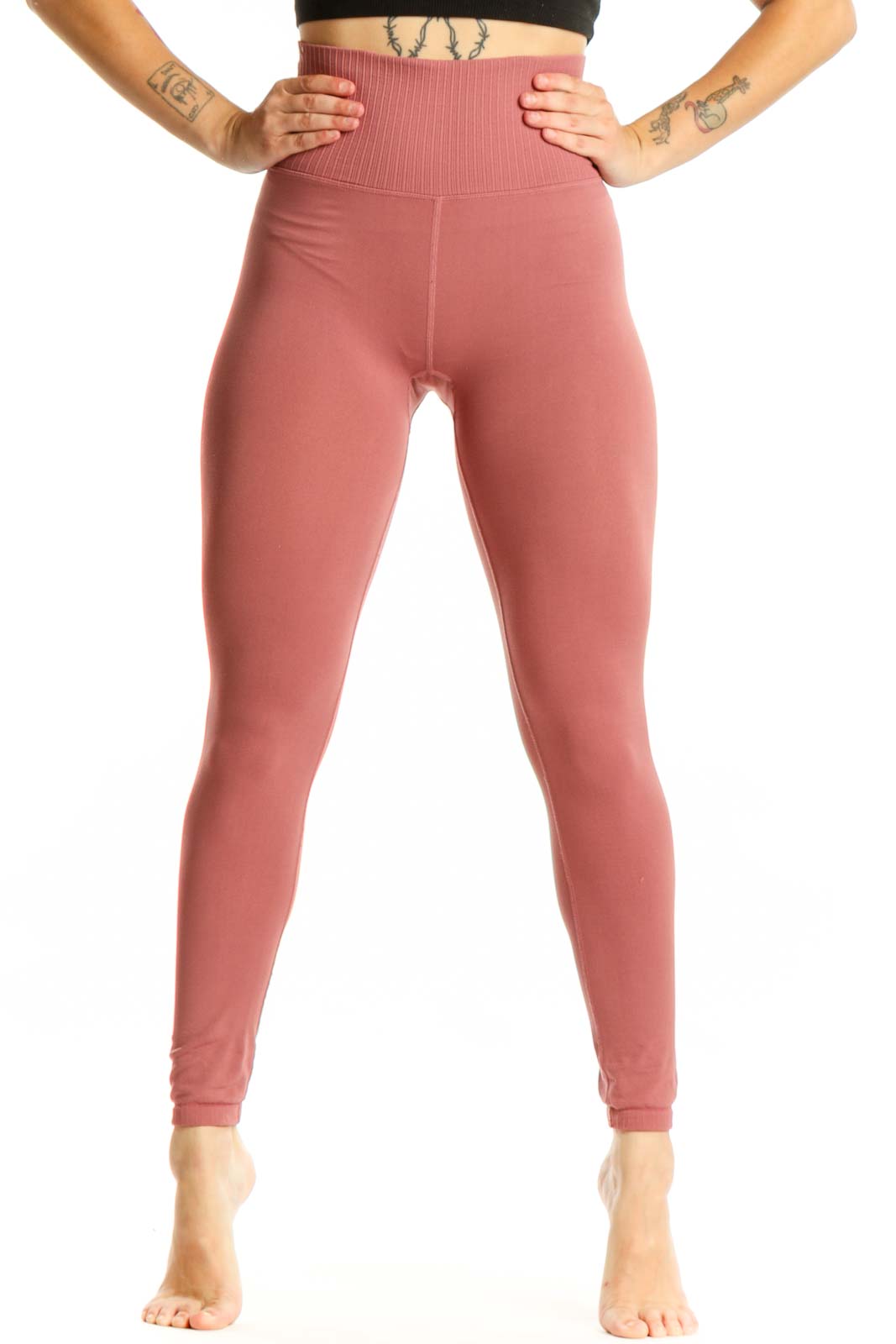 Woman wearing pink high-waist ribbed leggings with black sports bra, front view showing flattering fit and ribbed texture detail