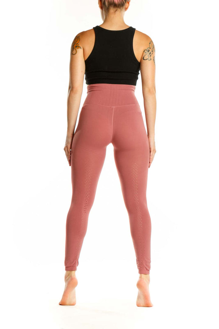 Back view of pink high-waist ribbed leggings on model, showcasing smooth silhouette and premium fabric quality