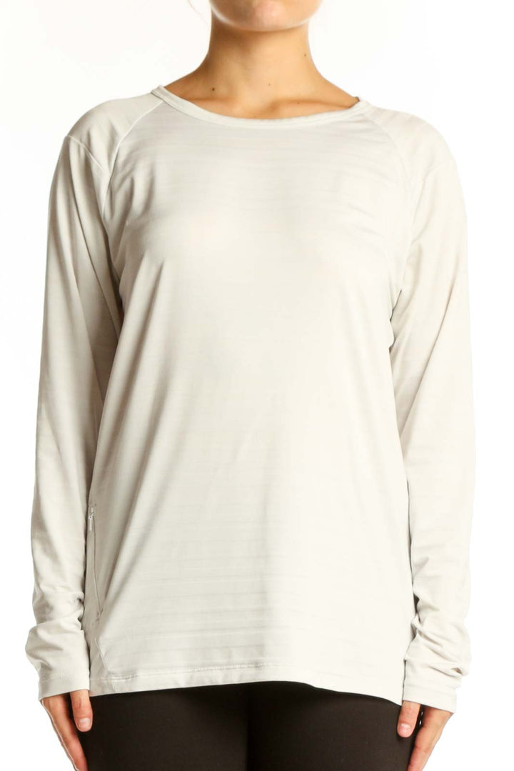Cream long sleeve athletic top with crew neckline, front view on model