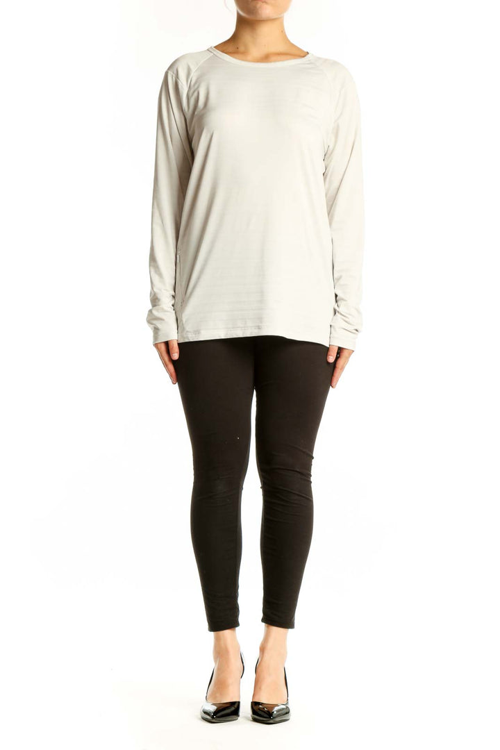Cream long sleeve athletic top with crew neckline, front view on model