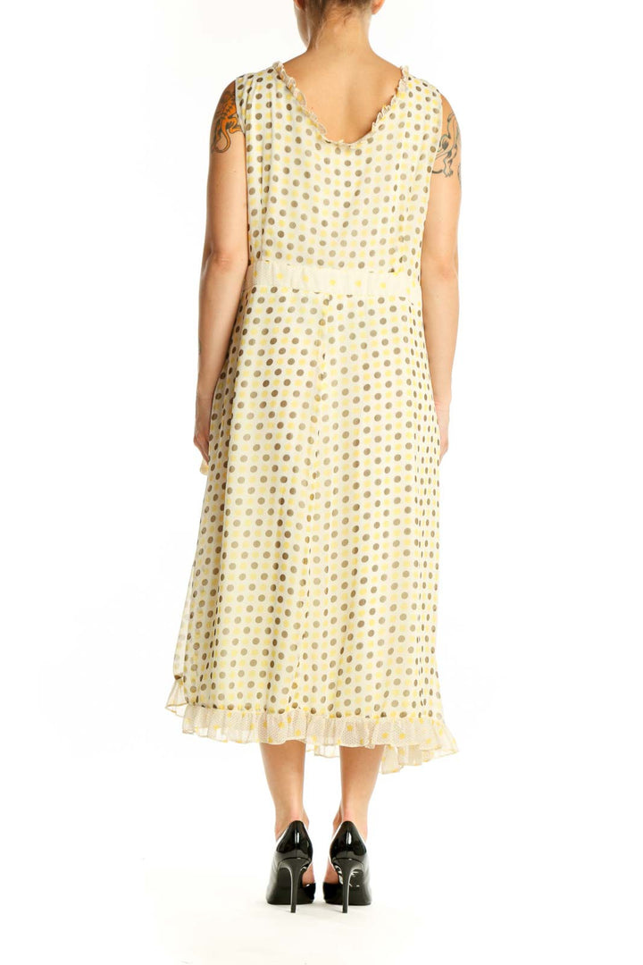 Back view of cream polka dot wrap midi dress showing pleated hem detail