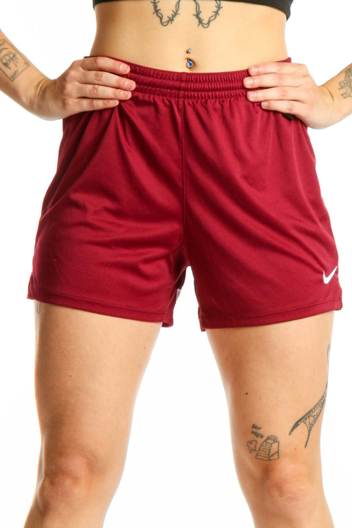Burgundy Nike athletic shorts front view with elastic waistband and Swoosh logo