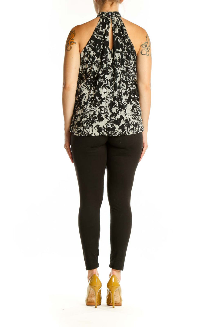 Black and cream abstract halter top with artistic print, back view on model