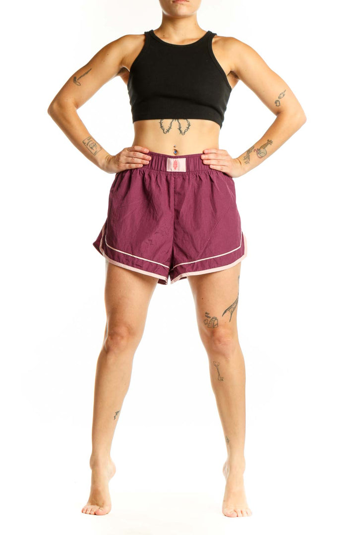 Burgundy athletic shorts with white contrast trim and elastic waistband, front view