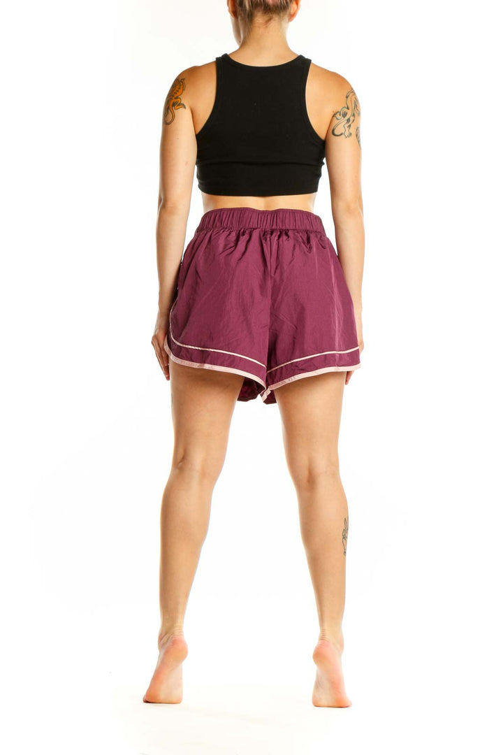 Burgundy athletic shorts with white contrast trim, back and side view