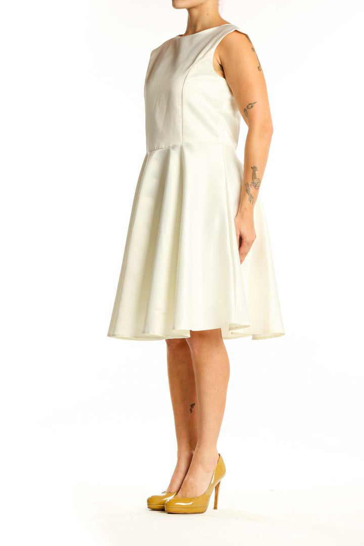 Front view of cream sleeveless A-line midi dress with crew neckline and flowing skirt
