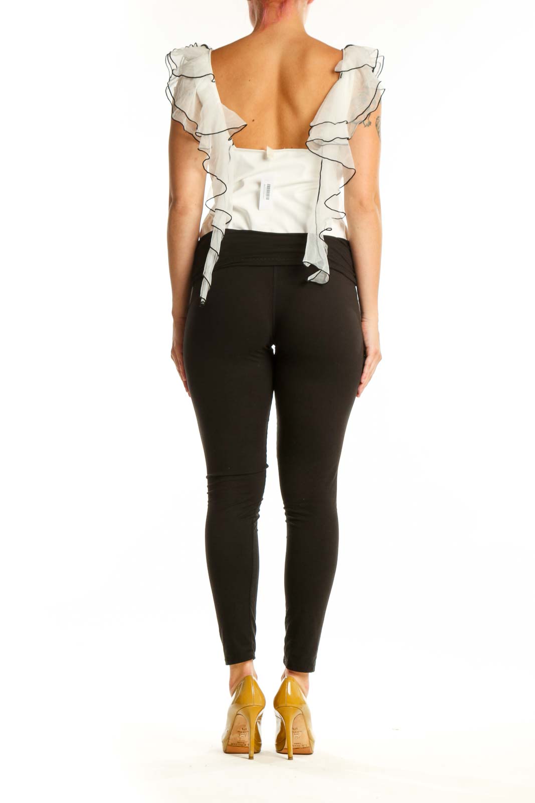 Back view of cream ruffled crop top showing voluminous shoulder ruffles and cropped silhouette