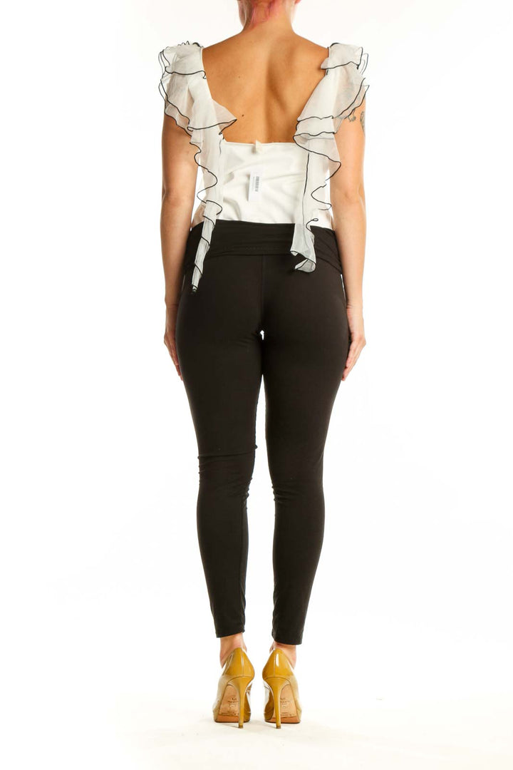 Back view of cream ruffled crop top showing voluminous shoulder ruffles and cropped silhouette