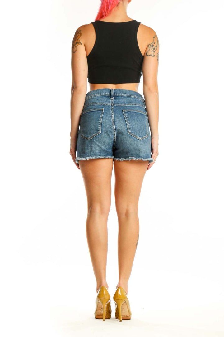 Back view of blue denim cut-off shorts showing distressed cut-off hem and fit